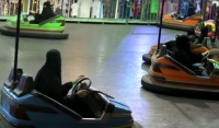 Saudi Arabian women use bumper cars to practice driving